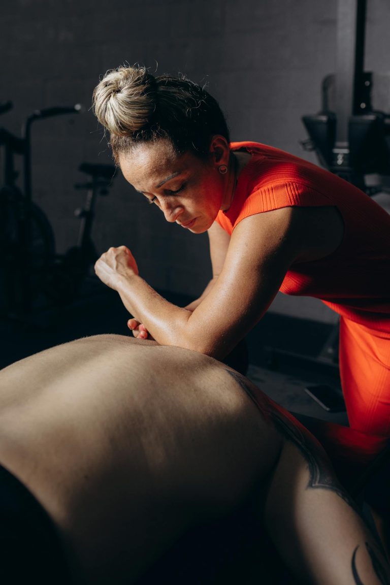 Focused therapist providing expert massage therapy in a fitness environment.