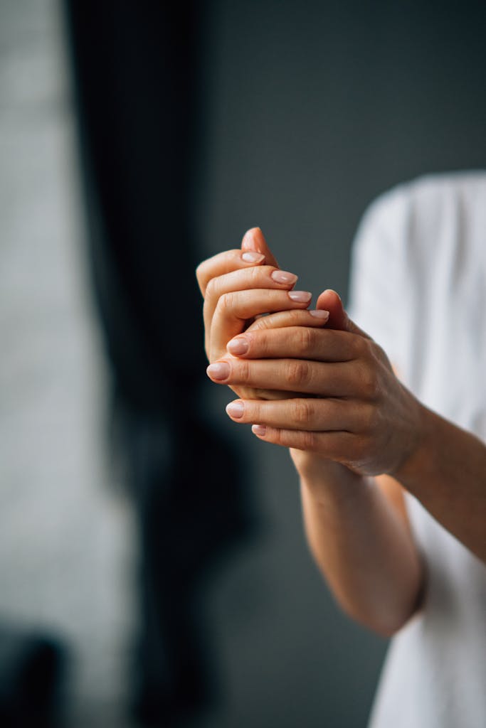 Elegant close-up shot of manicured hands with soft lighting, creating an intimate feel.