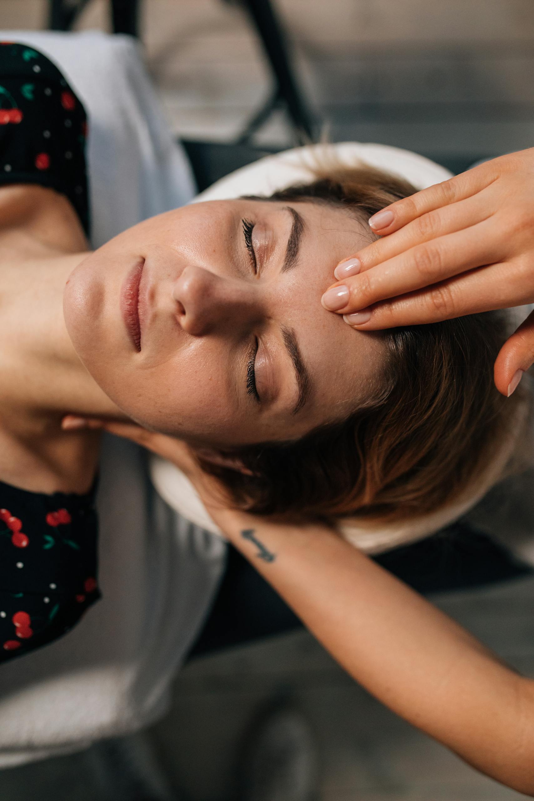 Woman receiving a soothing facial treatment at TheraTouch Wellness